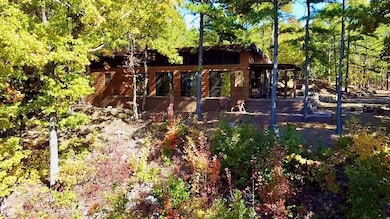 View of playground with a wooden deck, stairs, and a forest view