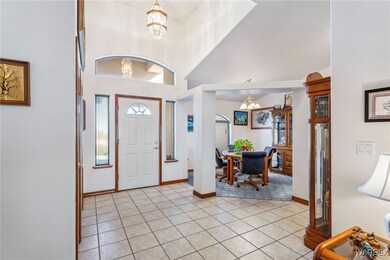 Tiled foyer entrance with high vaulted ceiling and