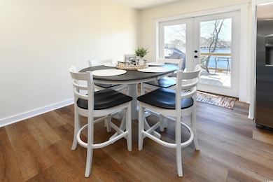 Dining area with wood finished floors, french doors, and baseboards