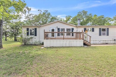 View of front of home with a deck, a front lawn, a
