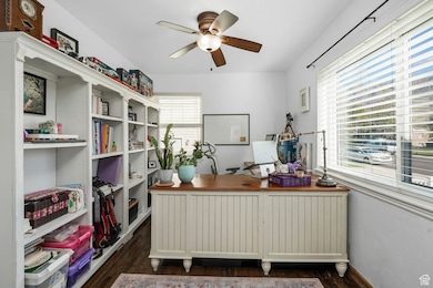 Office with plenty of natural light, dark wood-type flooring, and a ceiling fan