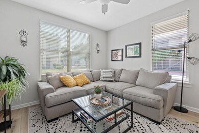 Living room featuring a ceiling fan and light woo