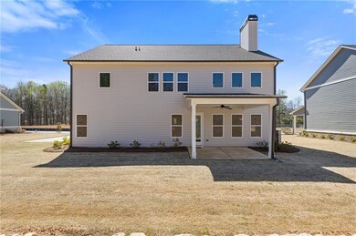 Rear view of house with a chimney, a ceiling fan, 
