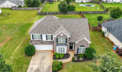 View of front of home featuring brick siding, an attached garage, and driveway