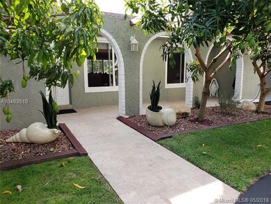 Front of house with mango trees and travertine wal