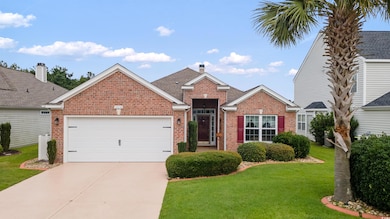 Traditional home with brick siding, concrete driveway, an attached garage, a front lawn, and a chimney