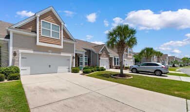 View of front of home with driveway, an attached garage, a front lawn, and a residential view