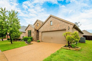 View of front facade featuring brick siding, driveway, and an attached garage