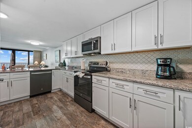 Kitchen featuring white cabinetry, appliances with stainless steel finishes, decorative backsplash, and light stone countertops
