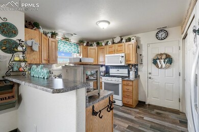 Kitchen featuring white appliances, light brown ca