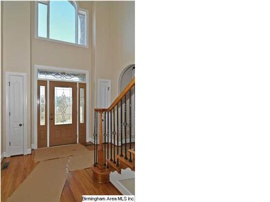 Grand foyer with soaring ceilings and hardwood flo