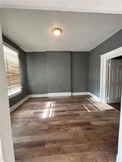 Unfurnished room with dark wood-style flooring and a textured ceiling