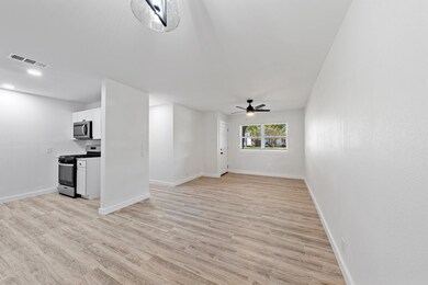 Unfurnished living room featuring ceiling fan and 
