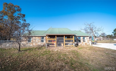 Cabin with stone siding and a metal roof