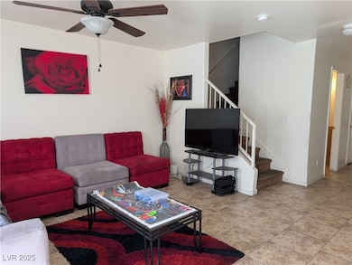 Living area featuring stairs, tile patterned floor