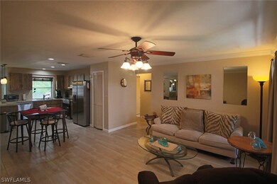 View from front door of living room, dining area, and open kitchen. Hallway to guest bedrooms and bathroom in center background of photo.