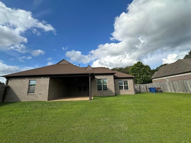 Rear view of property with a fenced backyard, a patio, brick siding, and a shingled roof