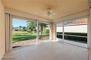 Unfurnished sunroom with a ceiling fan and healthy