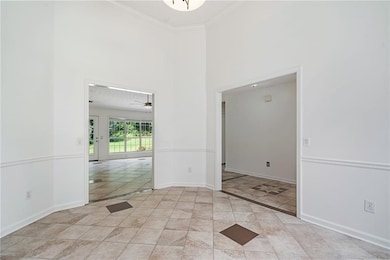 Dining room featuring a towering ceiling, crown molding, ceiling fan, and light tile patterned floors