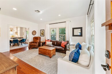 Cozy, well-lit living room with hardwood floors. T