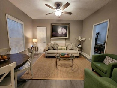 Living area with baseboards, ceiling fan, and wood finished floors