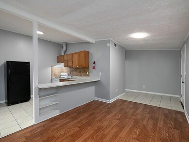 Kitchen with freestanding refrigerator, light wood finished floors, white range with electric stovetop, open shelves, and decorative backsplash
