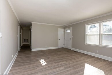 Living Room: Features include new LVP flooring, 2 windows for natural lighting and blinds for privacy, fresh new paint and decorative crown molding. To the left is the main hallway to the bedrooms and main hall bathroom. The front entry door is the right side and the closet is just to the left of the front door.