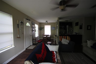 Living room featuring a ceiling fan, baseboards, 