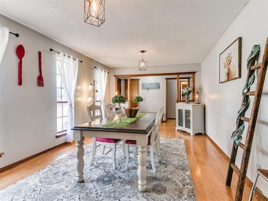 Home office with light wood finished floors, a textured ceiling, and baseboards