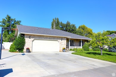 Ranch-style home featuring brick siding, concrete driveway, an attached garage, covered porch, and roof with shingles