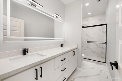 Bathroom featuring vanity, a shower with shower door, and toilet