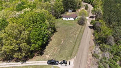 Aerial view of property and surrounding area featuring a forest