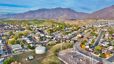 Aerial view of property's location with nearby suburban area and a mountainous background
