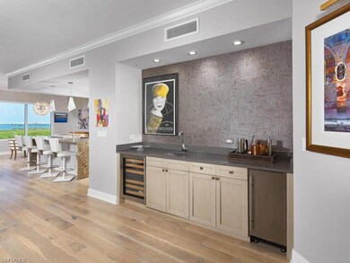 Bar with light hardwood / wood-style floors, sink,