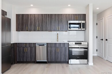 Kitchen featuring light countertops, appliances with stainless steel finishes, light wood-type flooring, modern cabinets, and recessed lighting
