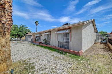 Rear view of property with a gate and stucco sidin