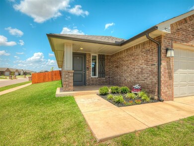 View of exterior entry with a garage, brick siding, and covered porch