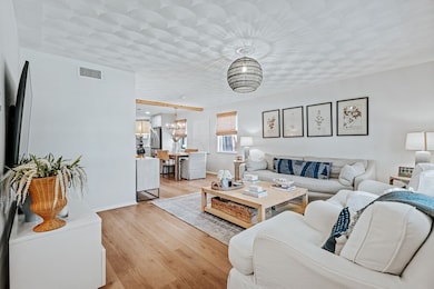 Living area featuring light wood-style flooring and a chandelier