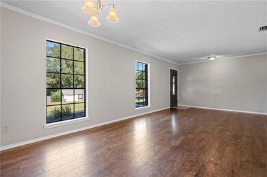 Unfurnished room with crown molding, wood finished floors, a chandelier, and a textured ceiling