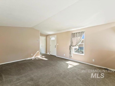 Foyer featuring vaulted ceiling and carpet