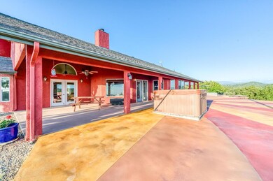 Generously sized back covered patio. French doors at left lead into the owner's suite. French doors in center of picture lead into main living area. Custom stained back patio extension with hot tub.