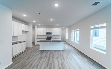 Kitchen featuring white cabinetry, stainless stee