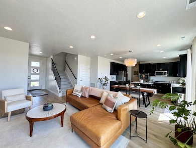 Living room featuring light wood-style flooring, recessed lighting, stairway, a textured ceiling, and a chandelier