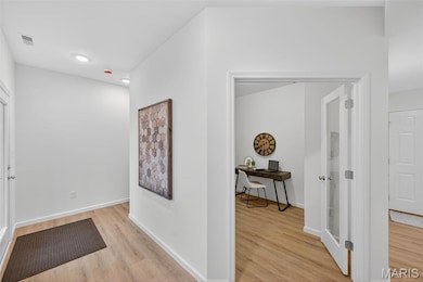 Hall with light wood-style flooring, recessed lighting, and an office area