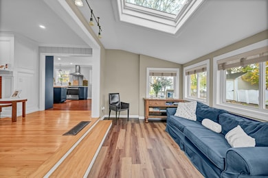 Sunroom entry into main living space with gleaming hardwood flooring.