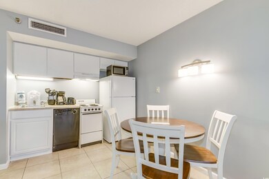 Kitchen with white cabinets, light tile patterned 
