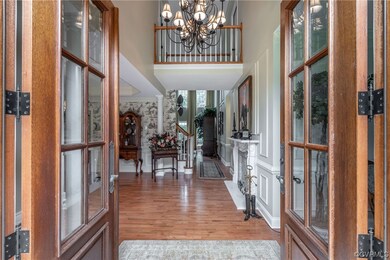 Entryway with hardwood flooring, a high ceiling, a