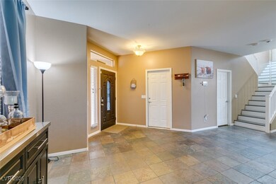 Foyer featuring stone tile floors and stairs