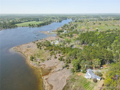 Birds eye view of property with a forest view and a water view