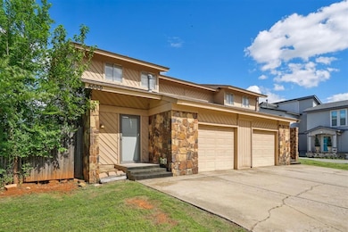 View of front of house featuring stone siding, a f